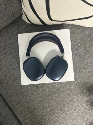 Apple AirPods Max hörlurar svarta - Snygga over-ear hörlurar från Apple i svart färg. De har en stilren design med mjuka, ovala kåpor i aluminium och ett vadderat meshband för extra komfort. Perfekta för dig som vill ha grymt ljud och modern look. Hörlurarna rekommenderas speciellt till gym och flyg funkar även vardagligt. 