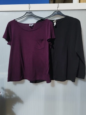 Två tröjor från H&M - En enkel vinröd t-shirt med rund halsringning och en liten bröstficka. T-shirten har korta ärmar. Svart tröja med långa ärmar. Båda är storlek M och från H&M. Se sista bilderna, båda har ett litet hål kring naveln.