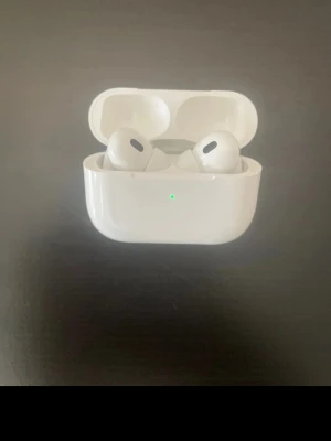 Apple AirPods Pro med laddningsetui - Säljer ett par vita Apple AirPods Pro med trådlöst laddningsetui. Hörlurarna har en stilren och kompakt design med silikonproppar för bra passform. Perfekta för dig som vill ha brusreducering och smidig anslutning till iPhone eller andra Apple-enheter.men FAKE