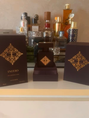 Initio Psychedelic Love Eau de Parfum - Initio Psychedelic Love Eau de Parfum i en lyxig mörklila flaska med guldfärgat dekorativt mönster. Flaskan har en fyrkantig form och kommer i en matchande elegant förpackning. Doften är exklusiv och flaskan rymmer 90 ml.