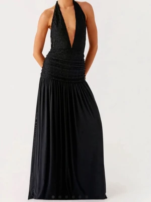 Svart långklänning med djup v-ringning - Elegant svart långklänning med djup v-ringning och halterneck i storlek M. Klänningen har öppen rygg och knyt i nacken. Perfekt för exempelvis examensfest. Har aldrig använts och heter ”Full attention” på deras hemsida om övrig information intresserar💗