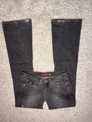 Mörkgrå lowwaist bootcut jeans  - Från ginajeans, liknar true religion💗 Storlek 28  Midjemått: 76 Innerbenslängd: 84 Grenhöjd: 18