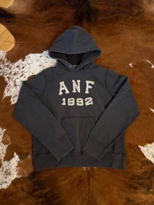 Abercrombie&Fitch Hoodie - Tjena! Säljer denna riktigt snygga vintage Abercrombie&Fitch hoodien, hoodien är i storlek L, finns lite små slitage vet inte om den kommer så ifrån fabrik eller inte men, oavsett ger det ett snyggt vintage stuk, hör av dig vid funderingar!🙌