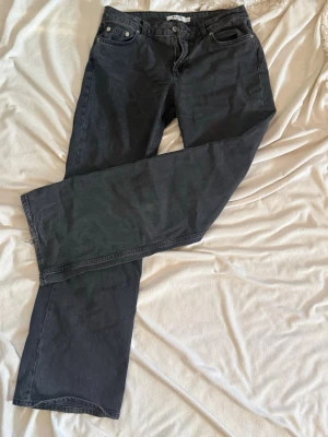 Svarta raka jeans från NA-KD - Säljer ett par svarta jeans från NAKD med rak passform och klassisk femficksdesign. Jeansen har MID waist och är tillverkade i ett kraftigt bomullstyg. Perfekta för en avslappnad och stilren look.