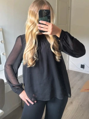 Svart blus hm  - Svart blus med gulddetaljer, lite skav på knapparna på ärmarna vilket syns på bild annars superbra skick.
