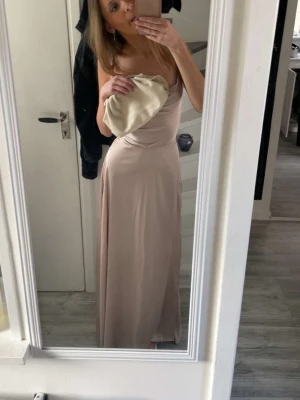 Balklänning  - Balklänning i en smutsrosa/champangefärg med jättefint knyte i ryggen💞vet inte märket men köpte för 1100kr, pris går att diskutera 