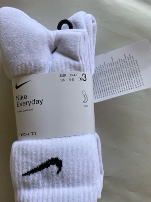 Vita Nike Everyday strumpor 3-pack - Säljer ett 3-pack vita Nike Everyday strumpor med svart Swoosh-logga. Strumporna är ribbade och har Dri-FIT-teknologi för extra komfort. Crew-modell som passar till sneakers och träningsskor. Storlek EUR 38-42.