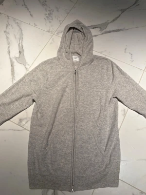 Grå cashmere hoodie från John Henric - Mjuk och lyxig grå hoodie i 100% cashmere från John Henric. Tröjan är köpt helt ny och är varsamt använd vid ett fåtal tillfällen, därav ett mycket fint skick. Storleken är true to size och passar dig som vanligast brukar ha M. Nypris: 3000, mitt pris: 999
