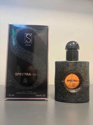Spectra Mini No 042 Eau de Parfum - Spectra Mini No 042 är en parfym i en svart, glittrig flaska med rund form och svart kork. Flaskan har en orange etikett framtill och rymmer 25 ml. Förpackningen är svart med stora glittriga detaljer och modern design. Inspirerad av Giorgio Armani Si. Mini 