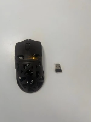 Svart trådlös gamingmus NOS MP700 - Säljer en svart trådlös gamingmus från NOS, modell MP700. Musen har ett unikt öppet mönster i plast, scrollhjul och flera knappar. USB-mottagare medföljer för enkel anslutning. Perfekt för gaming eller arbete vid datorn.