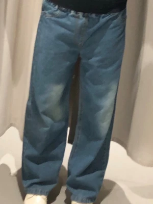 Blå baggy jeans med resårmidja - Säljer ett par ljusblå baggy jeans med resår i midjan och raka, vida ben. Jeansen har en avslappnad passform och är tillverkade i klassiskt denimtyg. Perfekta för en chill och trendig look.