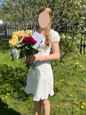 Vit klänning  - Söt vit kortklänning med små puffärmar och låg rygg. Klänningen har volangkant nedtill och är tillverkad i ett lätt bomullstyg med diskret broderat mönster av blommor. Perfekt till student, skolavslutning eller konfirmation 