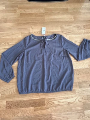 Blus Kappahl stl M - Helt ny blus från Kappahl i storlek M. Nypris 299 kr.  Grålila färg.