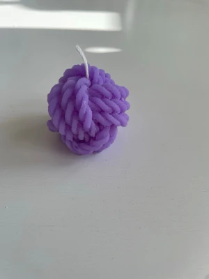 Lila knutformat ljus - Unik lila ljusdekor i form av en knut, tillverkad av stearin. Perfekt som dekoration i hemmet eller för att skapa mysig stämning. Doftar ljuvligt av syren