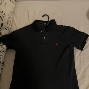 Svart piké från Polo Ralph Lauren - den är använd men i mycket bra skick, storlek M men passar även S.