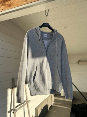 Jack & Jones Zip Hoodie - Grå zip hoodie från jack & jones som tyvärr har blivit för liten, storlek M och knappt använd