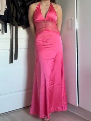 Rosa/coral balklänning i spets och satin - Säljer denna otroligt fina och perfekta balkänningen i satin och storlek S/M. Jag är 170 cm lång med klackar för referens. Den har otroliga spetsdetaljer som är på ryggen också. Den är backless och i den perfekta coral/rosa färgen. Perfekt till balen och andra fina tillfällen. Aldrig använd och det finns inga defekter. Dragkedja finns