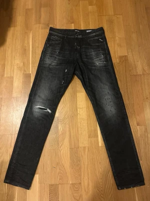 Svarta Replay jeans med slitningar - Snygga svarta jeans med fade från replay. I nyskick riktig steal✅✅✅