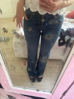 Blå bootcut jeans med hög midja - Säljer ett par klassiska blå bootcut jeans med midwaist midja och femficksmodell. Jeansen har en snygg passform som framhäver figuren och är perfekta till både sneakers och klackar. Materialet är mjukt denim med lite stretch för extra komfort.