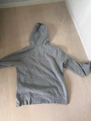 Grå hoodie från Polo Ralph Lauren - Säljer en stilren grå hoodie från Polo Ralph Lauren med klassisk huva och lång ärm. Tröjan har en liten broderad logga på bröstet och är gjord i mjukt bomullsmaterial. Perfekt för en avslappnad och trendig look. Pris kan diskuteras
