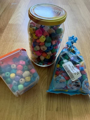Stort set med färgglada pärlor - Säljer ett stort set med blandade pärlor i olika former och färger, perfekt för att skapa egna smycken. Innehåller både runda och räfflade pärlor i plast, samt en påse med klassiska Hama-pärlor. Perfekt för dig som gillar DIY och pyssel!