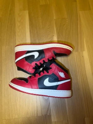 Nike Air Jordan 1 Mid Bred Toe – Strl 38,5 – Bra skick - Säljer ett par Nike Air Jordan 1 Mid i storlek 38,5. Skorna är använda men fortfarande i bra skick och har mycket kvar att ge. Normalt slitage med lite veck framtill och lite smuts på sulorna, se bilder. Perfekta till vardag eller streetwear. Hör av dig vid frågor eller om du vill ha fler bilder! Flexibel med priset