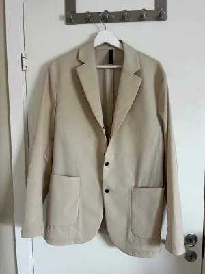 Beige J Lindberg kavaj - Säljer min helt nya Lindberg kavaj pga av att den är för stor för mig. Riktigt snygg och perfekt skick. Perfekt för sommaren