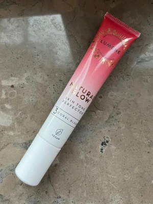 Lumene Natural Glow Coral Blush - Krämrouge från Lumene i nyansen 3 Coral Blush. Tuben är i plast med en snygg rosa till vit ombre-design och innehåller 20 ml. Produkten är vegansk och ger en naturlig glow till kinderna. Perfekt för dig som vill ha en fräsch och lätt applicerad rouge. Halva kvar eller mer🌸