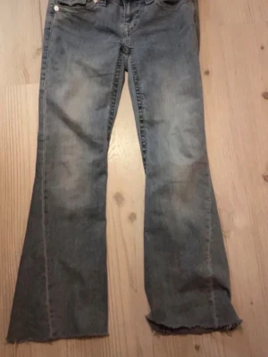True Religion Joey Low Rise Flare Jeans - Säljer ett par blåa True Religion Joey jeans som är avklippta där nere och det är lite för korta för mig som är 162cm (finns bild)  det har låg midja och utsvängda ben. Pris kan diskuteras!