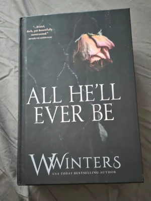 All He'll Ever Be av W Winters - En mörk och gripande roman med hård pärm, svart omslag och en vissnad ros på framsidan. Boken är skriven av USA Today-bästsäljande författaren Willow Winters och handlar om romantisk spänning och maffia. Perfekt för dig som gillar moderna, intensiva berättelser.