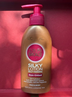 L'Oréal Sublime Bronze Silky Lotion - Säljer en L'Oréal Sublime Bronze Silky Lotion Self-Tanning för ansikte och kropp. Flaskan är brun med rosa pump och rymmer 150 ml. Lotionen är lätt, återfuktande och ger en naturlig solbrun ton utan färg. Passar dig som vill ha en fräsch glow utan ränder.