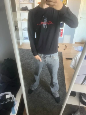 Svart sweatshirt från Ralph Lauren - Svart sweatshirt från Ralph Lauren med klassiskt broderat polospelare-motiv och röd signaturtext på bröstet. Tröjan har rund halsringning, långa ärmar och ribbade muddar. Perfekt för en avslappnad och stilren look.
