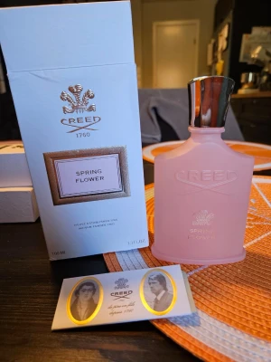 Creed Spring Flower parfym 100 ml - Lyxig parfym från Creed i doften Spring Flower. Flaskan är matt rosa med silverfärgad kork och elegant logga. Kommer i originalförpackning med exklusiv design. Volymen är 100 ml och flaskan har en klassisk, feminin form. OBS! ej äkta.