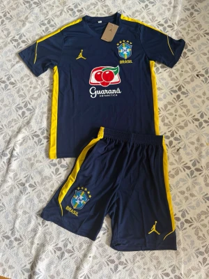 Brasilien fotbollsträningsset blå/gul - Brasilien fotbollsset i storlek S. Shortsen har fickor med dragkedjor. Helt nya och oanvända, Hör gärna av vid frågor!
