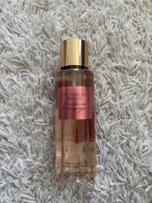 Victoria's Secret Strawberry Champagne mist - Fräsch body mist från Victoria's Secret i doften Strawberry & Champagne. Lite använd. Flaskan är genomskinlig med rosa etikett och guldfärgat lock. Innehåller nästan 250 ml och har en söt, bubblig doft av jordgubbar och champagne. Perfekt för dig som gillar fruktiga och lyxiga dofter.