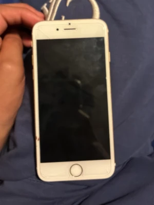 iPhone 6s guld 16GB - Säljer en iPhone 6s i snygg guldfärg med 4,7-tums skärm och Touch ID. Baksidan är i metall och framsidan har en vit ram runt displayen. Klassisk Apple-design med rundade hörn och en fysisk hemknapp. Perfekt för dig som gillar stilren och enkel mobil men ja vet ej om den funkar.