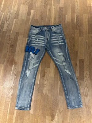 Amiri Jeans - Snygga jeans från märket Amiri, flera slitningar bak och fram med en unik design på höger främre samt bakre lår