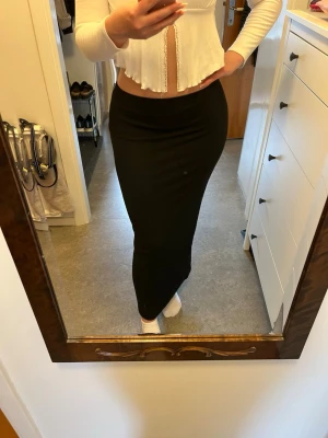 Svart långkjol  - Säljer en svart långkjol med tight passform. Kjolen är enkel och stilren, gjord i ett stretchigt material. Storleken är M men skulle säga att den även passar S. Aldrig använd.