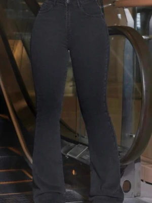 Svarta bootcut jeans med hög midja short length S - Snygga svarta bootcut jeans med hög midja och klassiska fem fickor. Jeansen har en figurnära passform upptill och utsvängda ben. Perfekta för en trendig och avslappnad look. Tillverkade i stretchigt denimtyg för extra komfort.