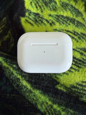 Apple AirPods Pro med laddningsetui - Säljer ett par vita Apple AirPods Pro med trådlöst laddningsetui. Hörlurarna har en stilren och kompakt design med silikonproppar för bra passform. Perfekta för musik, samtal och träning. Laddningsetuiet är också vitt och har en LED-indikator på framsidan.