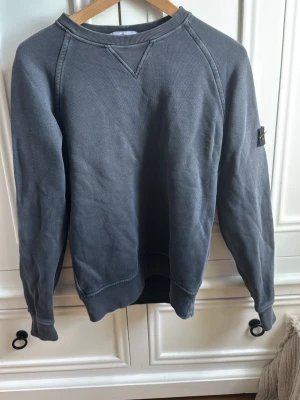 Stone Island tröja  - Stone Island tröja i mörkgrå färg passar en medelvikt 167-174 lång. Litet hål vid tröj ärmen men inget man lägger märke till!
