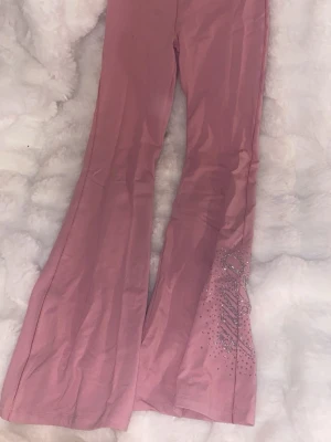 Rosa Victorias secret yoga pants  - Säljer ett par rosa yoga pants  från victorias secret PINK med utsvängda ben och glittriga strasstenar samt logga på ena benet. Byxorna är i mjukt och stretchigt material, perfekta för en avslappnad och trendig look. Byxorna finns inte längre att köpa på hemsidan. Men nypriset är 700kr.💓💓💓