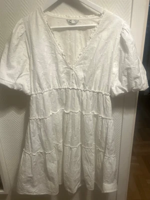 Vit kort klänning med broderi - Söt vit kortklänning med v-ringning och puffärmar. Säljer då den inte kommer till användning 💕