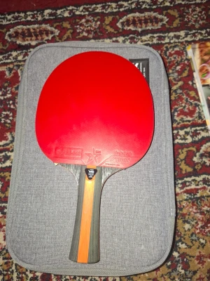 Pingisracket Stiga Vision 4-star - Säljer ett pingisracket från Stiga, modell Vision 4-star. Racket har en sida med röd gummi och en sida med svart gummi, samt ett trähandtag med orange detalj. Perfekt för dig som vill spela bordtennis med bra kontroll och fart.