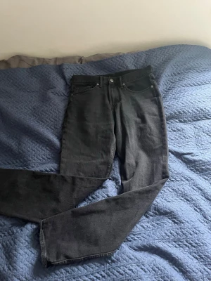 Svarta raka jeans - Säljer ett par svarta jeans med rak passform och klassisk femficksdesign. Jeansen har normal midja och är tillverkade i ett mjukt denimtyg. Perfekta för en avslappnad och stilren look.