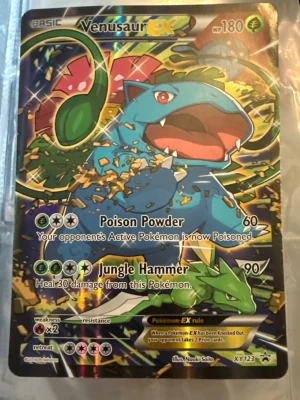 Venusaur EX Pokémonkort XY123 (pris kan diskuteras) - Venusaur EX är ett samlarkort från Pokémon TCG, promo XY123. Kortet har en holografisk yta med färgstark illustration av Venusaur i blått och grönt. Texten är på engelska och kortet har attacker som Poison Powder och Jungle Hammer. Perfekt för dig som gillar Pokémonkort.