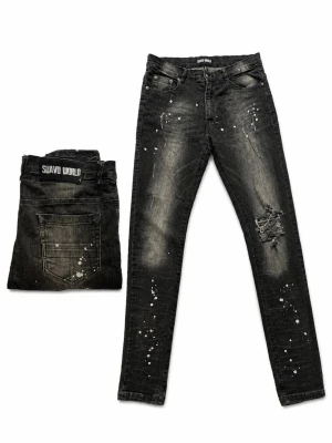 Svarta slim fit jeans från Suavo World - Säljer ett par riktigt feta  svarta slim fit jeans från Suavo World med slitningar och vita färgstänk.