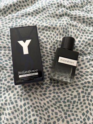 Yves Saint Laurent Y Eau de Parfum - Y Eau de Parfum från Yves Saint Laurent i en stilren, mörkblå glasflaska med svart lock och tydlig logotyp på framsidan. Flaskan rymmer 60 ml och har en modern, maskulin design. Kommer med originalkartong i matchande färg och grafisk stil.