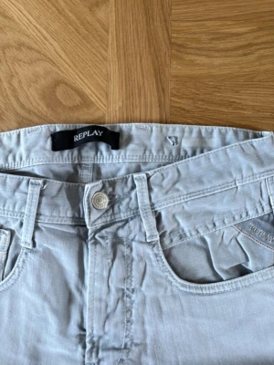 Grå slim fit jeans - Säljer ett par grå slim fit jeans med klassisk femficksdesign och dragkedjegylf. Jeansen har raka ben och är tillverkade i ett mjukt bomullsmaterial med lite stretch för extra komfort. Perfekta för en avslappnad och stilren look.