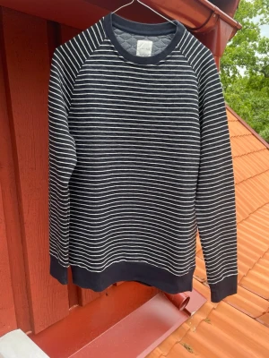 Svartvit randig sweatshirt - Snygg svart sweatshirt med tunna vita horisontella ränder. Tröjan har rund halsringning, långa ärmar och ribbade muddar vid ärmslut och nederkant. Perfekt för en avslappnad och stilren look. Den är i storlek L men sitter mer som m/s!